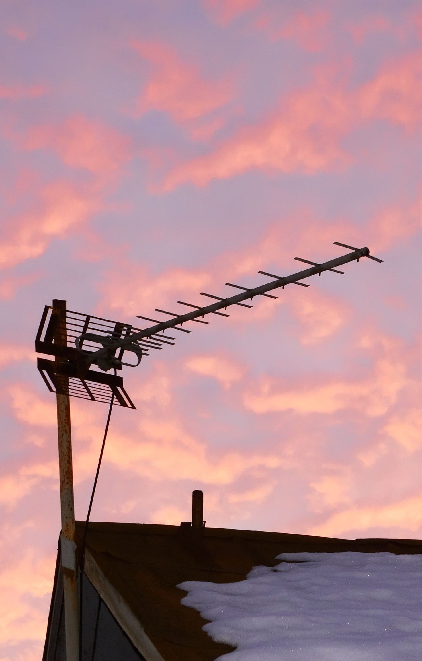 Outdoor TV antenna on a roof at sunset